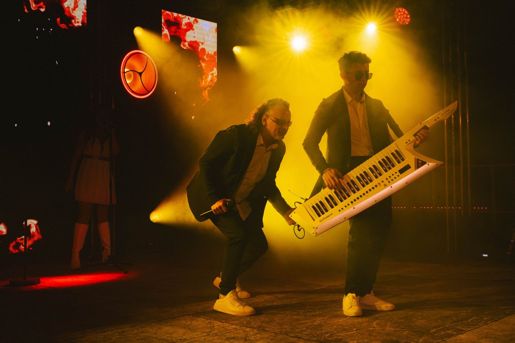 Le chanteur et le claviériste sur scène sous une lumière jaune