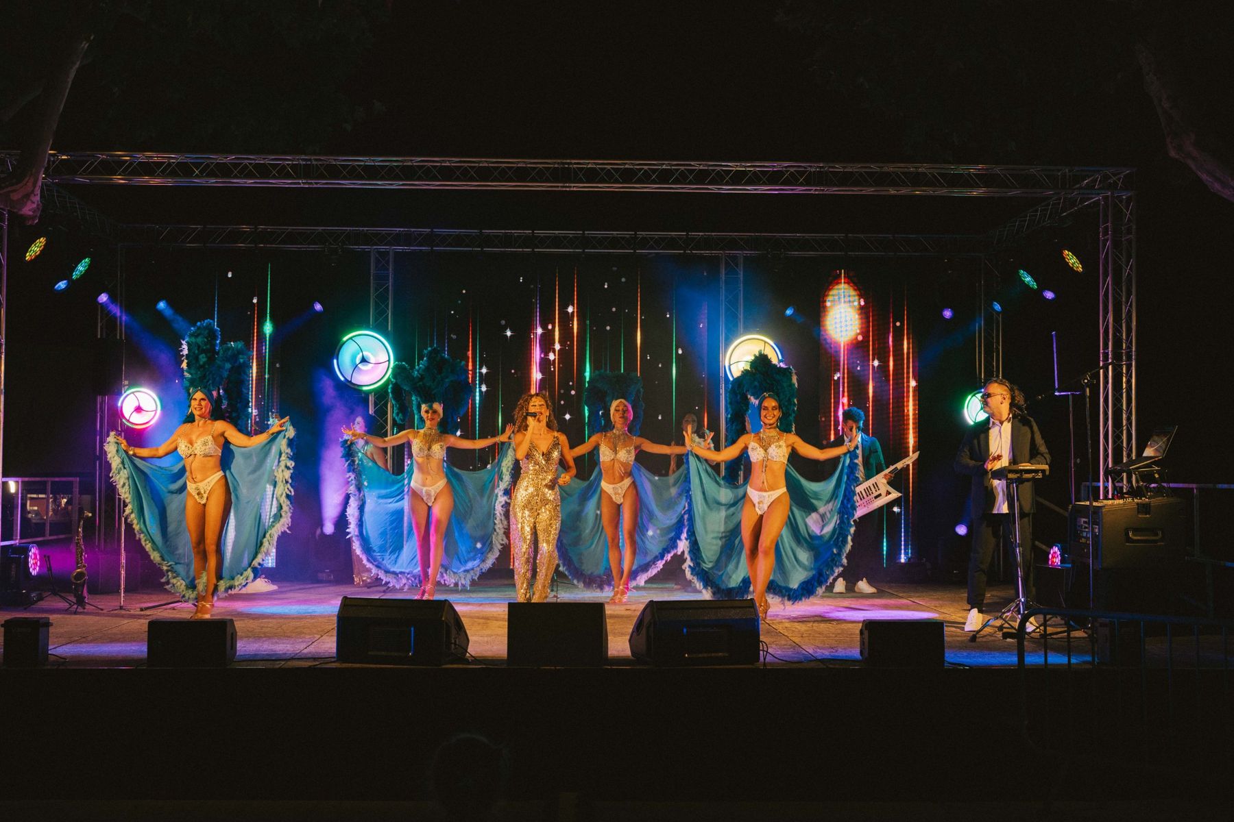 Chanteuse et danseuses à plumes sur la scène du Show DISCO