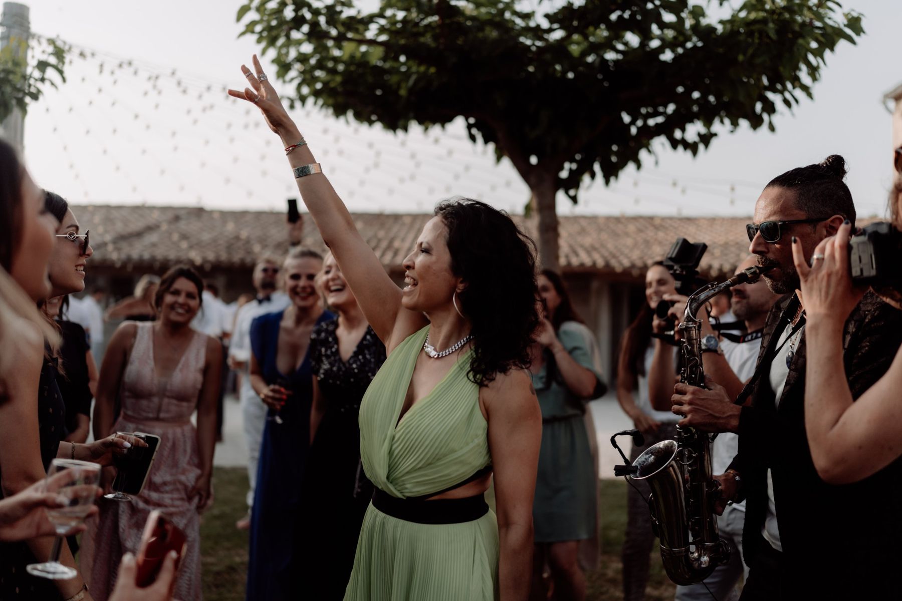 Une invitée danse avec le saxophoniste pendant un cocktail de mariage